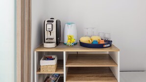 A kitchenette with a coffee maker, a kettle, a fruit basket, and a wicker basket on a wooden shelf. - De Vivo Realty - Boscosfera Amalfi (Amalfi)