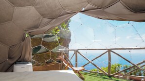 A room with a bed, a view of the outdoors, and a hexagonal structure. - De Vivo Realty - Boscosfera Amalfi (Amalfi)