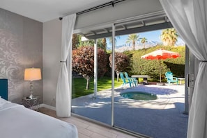 Ein Schlafzimmer mit einer Glasschiebetür, die zu einem Poolbereich führt.