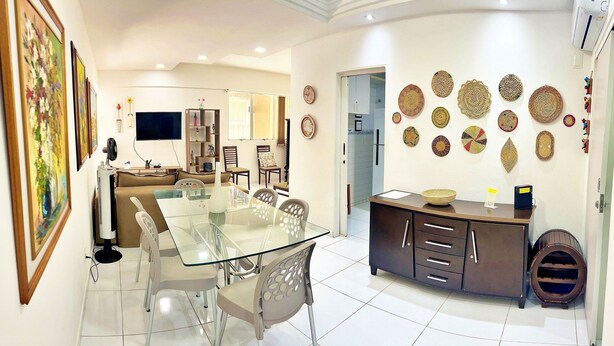 A modern living room with a glass dining table, a sofa, and a TV. - Vacanze - Don Felipe (Maceió)