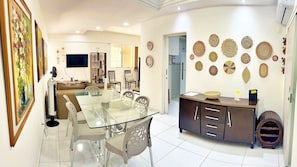 A modern living room with a glass dining table, a sofa, and a TV. - Vacanze - Don Felipe (Maceió)