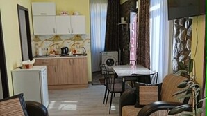 Un espacio habitable compacto con kitchenette, comedor y zona de estar.