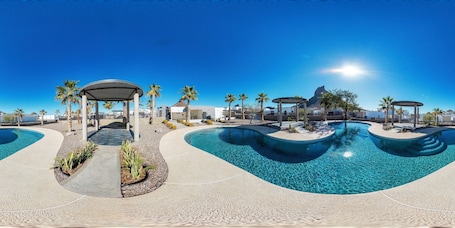 A pool area with clear water, palm trees, and covered seating areas.. Luxury San Carlos Beach House | Pool, Pickleball & Kayaks