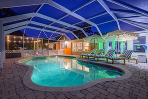 A swimming pool with a covered area, lounge chairs, and a small pavilion. - Bradenton Vacation Haven | Pool, Hot Tub, Arcade (Bradenton)