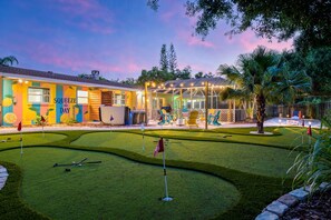 A golf course with a building featuring a colorful mural and a covered seating area. - Bradenton Vacation Haven | Pool, Hot Tub, Arcade (Bradenton)