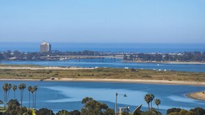 Eine Küstenlandschaft mit einer Brücke, einem hohen Gebäude und einem Strand.