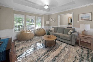 A living room with a sofa, coffee table, bean bag chairs, and a rug. - Isleview Retreat on Callendar Lake (Murchison)