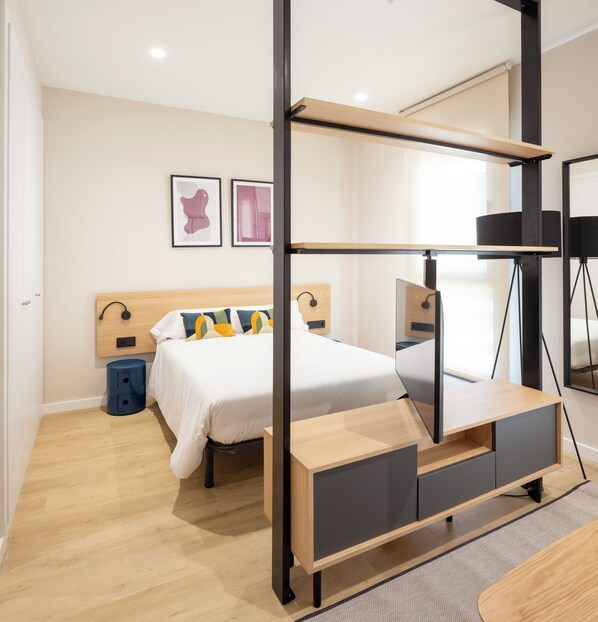 Un dormitorio moderno con una litera, mesitas de noche, un escritorio y una silla.