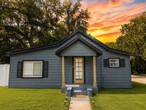 A single-story house with a front porch, a front door, and a small window on the right side. - Cozy Corner House|Backyard|Fire Pit | Pet Friendly (Kissimmee)