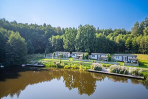 A lakeside property with multiple cabins, a dock, and a forested backdrop.