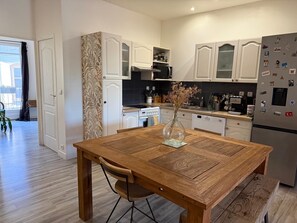 Eine moderne Küche mit weißen Schränken, einem Holzespeisetisch und einem Kühlschrank mit Magneten.