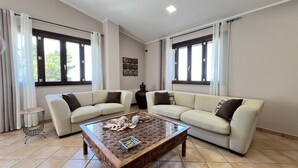 Una sala de estar con dos sofás, una mesa de centro y una mesita auxiliar.
