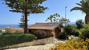 A coastal building with a tiled roof, stone walls, and a stone pathway leading to the entrance. - Appartamento Miranda Oro - Caste... (Castellammare del golfo)