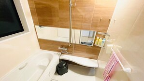 Ein Badezimmer mit Badewanne, Dusche, Waschbecken und Spiegel.