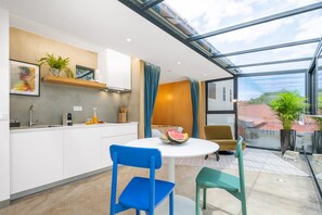 A modern kitchen with white cabinets, a built-in microwave, and a fruit bowl on the island. - The 21 - Sky by Homie (Ribeira Brava)