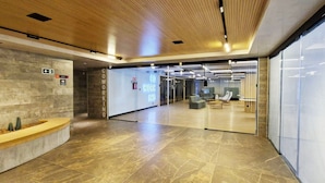A modern lobby with a reception desk, a glass partition, and a sign for Coworking. - COCAZ0109 - Condominio LIT 760 (Salvador)