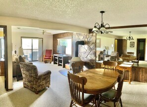 A spacious living area with a fireplace, dining table, and comfortable seating.