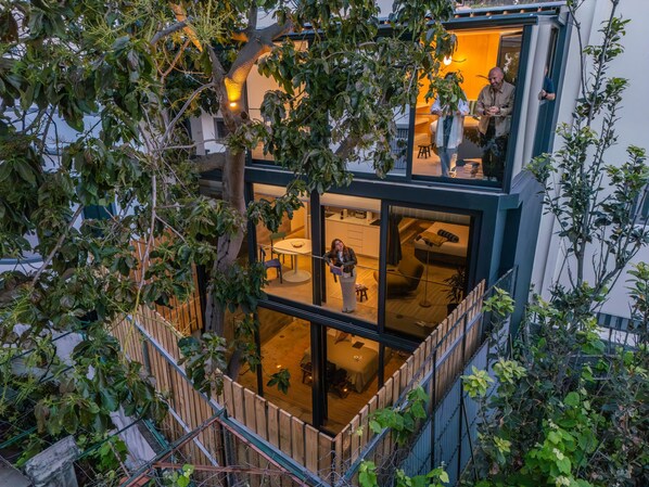 Ein modernes Haus mit einem Glasbalkon, einem Essbereich und einem Wohnzimmer.