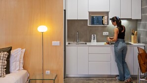 A compact kitchen with white cabinets, a built-in microwave, and a sink. - The 21 - Gaia by Homie (Ribeira Brava)