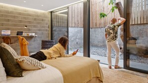 A modern interior with a bed, a desk, and a large glass door leading to an outdoor area. - The 21 - Gaia by Homie (Ribeira Brava)
