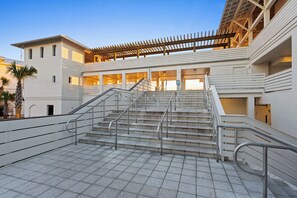 A modern building with a central staircase, multiple balconies, and a covered outdoor area. - Watercolor Condo w/ Exclusive Pool Access (Santa Rosa Beach)