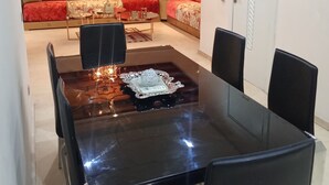 Un espace repas avec une table noire, des chaises et un élément décoratif central.