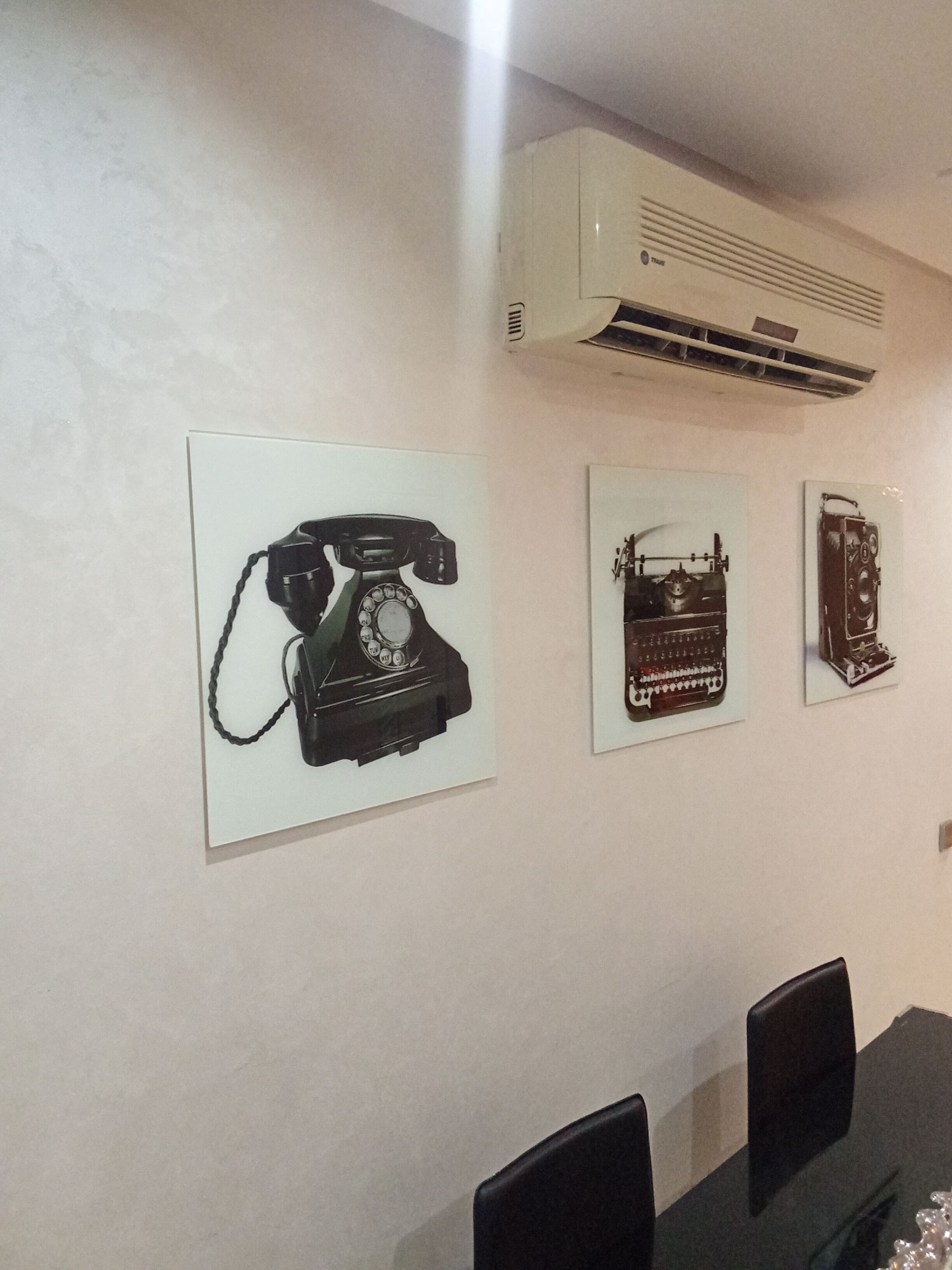 A conference room with a table, chairs, and three framed pictures on the wall.
