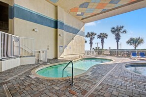 Ein Poolbereich mit zwei Pools, einer Treppe und Palmen im Hintergrund.