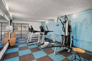 A gym with cardio machines, weight equipment, and a check-in counter. - Oceanfront Two Queen Room + Lazy River & Hot Tub (Myrtle Beach)