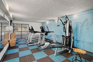 A gym with cardio machines, weight equipment, and a check-in counter. - Oceanfront Two Queen Room + Lazy River & Hot Tub (Myrtle Beach)