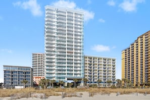 A multi-story hotel with balconies, a central atrium, and a beach view. - Resort View King Standard Room + Lazy River & Hot Tub (Myrtle Beach)