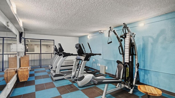 A gym with cardio machines, weight equipment, and a check-in counter. - Oceanfront Two Queen Room + Lazy River & Hot Tub (Myrtle Beach)