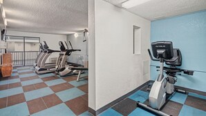 Ein Fitnessraum mit Ergometer, Laufbändern und einem an der Wand befestigten Trainingsgerät.