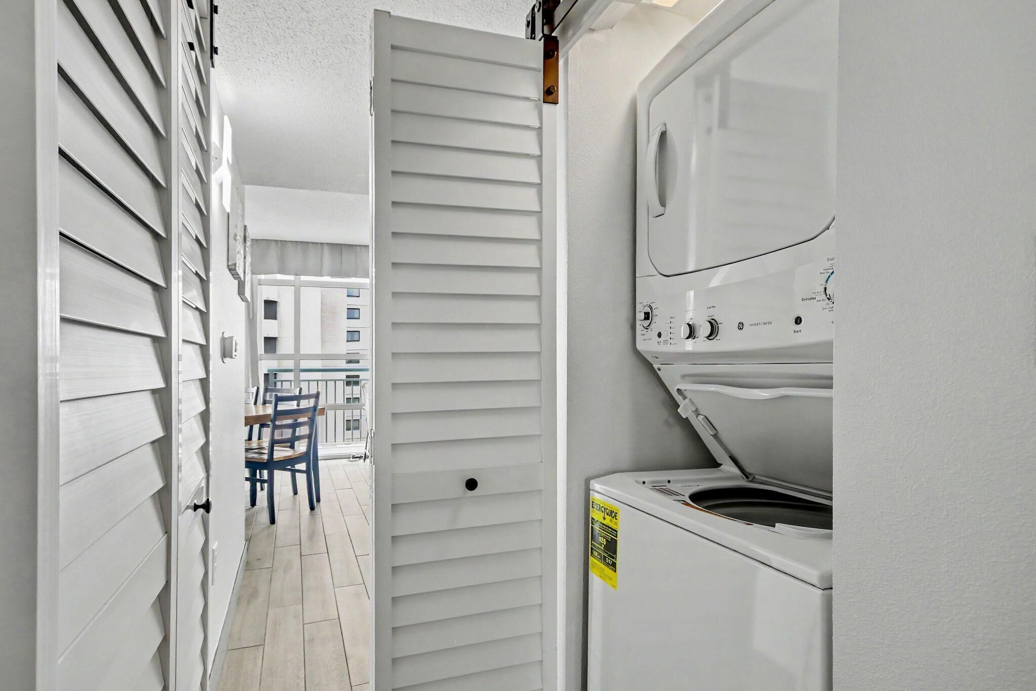 Une buanderie équipée d’un lave-linge, d’une porte et d’une table avec des chaises.