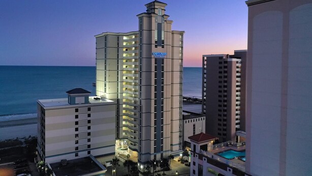 Un hôtel de grande hauteur, doté d’une tour imposante, de nombreux balcons et d’un espace piscine.