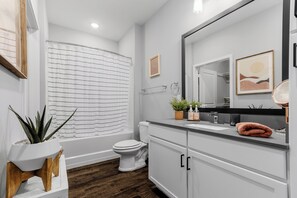 Une salle de bain moderne équipée d’une baignoire, de toilettes et d’un lavabo.