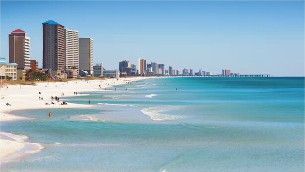 A beach with clear water, a pier, and high-rise buildings in the background. - Ocean Ritz 2001! Gulf Views, 4BR Penthouse Beachfront Escape (Panama City Beach)