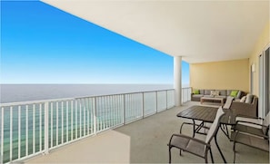 A balcony with a view of the sea, a sofa, and a table. - Ocean Ritz 2001! Gulf Views, 4BR Penthouse Beachfront Escape (Panama City Beach)