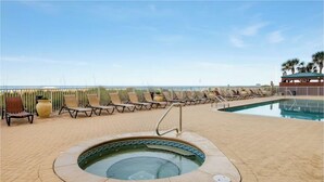A poolside area with lounge chairs, a hot tub, and a view of the ocean. - Ocean Ritz 2001! Gulf Views, 4BR Penthouse Beachfront Escape (Panama City Beach)