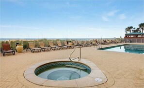 A poolside area with lounge chairs, a hot tub, and a view of the ocean. - Ocean Ritz 2001! Gulf Views, 4BR Penthouse Beachfront Escape (Panama City Beach)