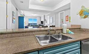 A modern kitchen with granite countertops, stainless steel sinks, and teal cabinetry. - Ocean Ritz 2001! Gulf Views, 4BR Penthouse Beachfront Escape (Panama City Beach)