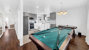 Ett modernt kök med vita skåp, en mikrovågsugn och en tvättmaskin.