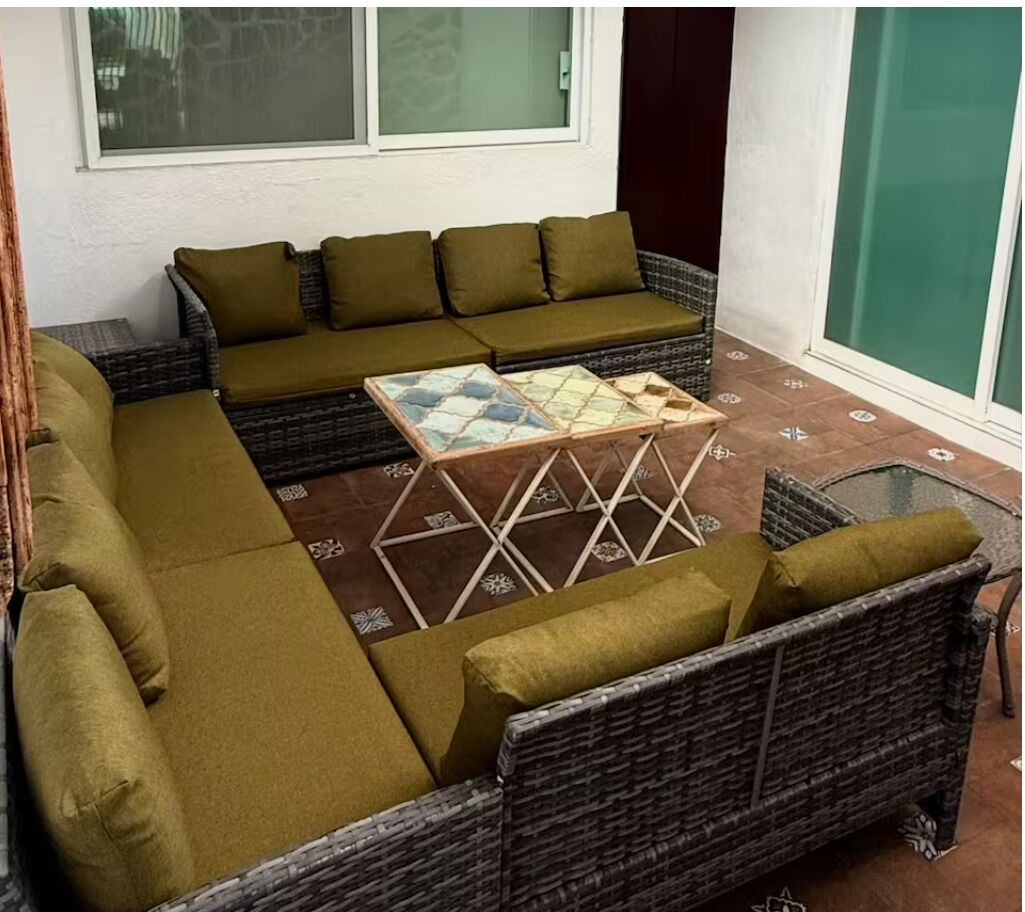 A sectional sofa with matching cushions, a glass-top coffee table, and wicker furniture.