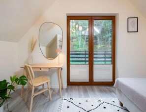 A bedroom with a desk, chair, bed, and a view of the outdoors through a sliding door. - Comfortable Holiday Villa, Sauna, Jacuzzi (Brzeznica)