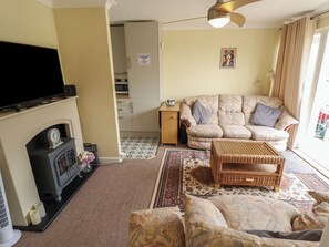 Ein Wohnzimmer mit Kamin, Sofa und Fernseher.
