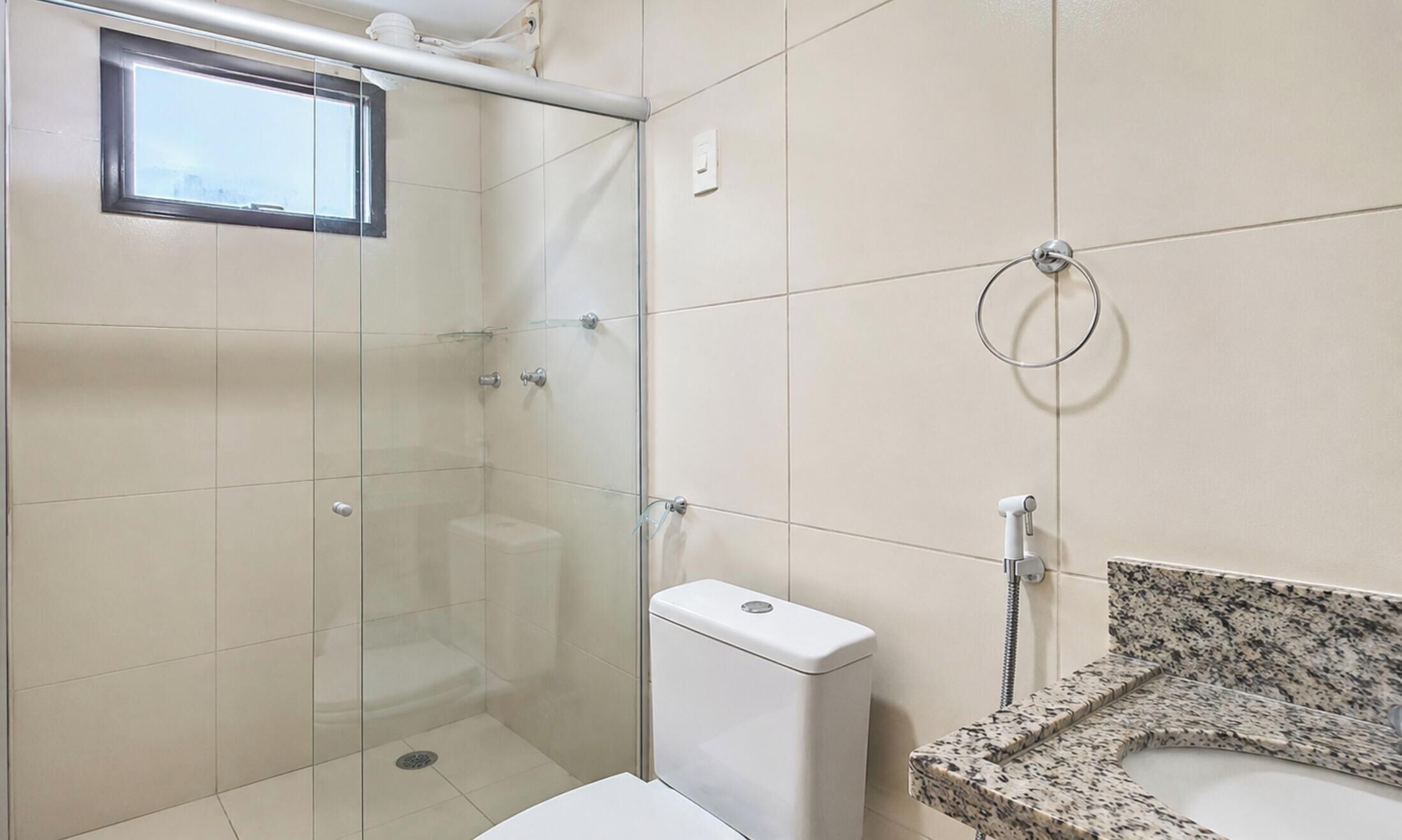 Une salle de bain avec une douche à parois de verre, des toilettes et un lavabo avec un plan de travail en granit.
