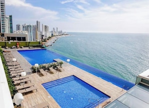 A rooftop pool with a view of the ocean and city skyline. - Stunning Oceanfront Luxury H2 Condo Next to Hyatt Cartagena (Cartagena de Indias)