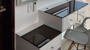 Quarto moderno com uma janela grande, uma escrivaninha e uma cadeira.