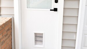 A white door with a window, a small vent below, and a black handle. - Private Guest House Free Parking 20min to IAH Airport (Houston)