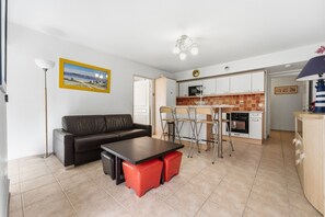 Ein gemütlicher, kompakter Wohnbereich mit Sofa, Esstisch und Küchenzeile.